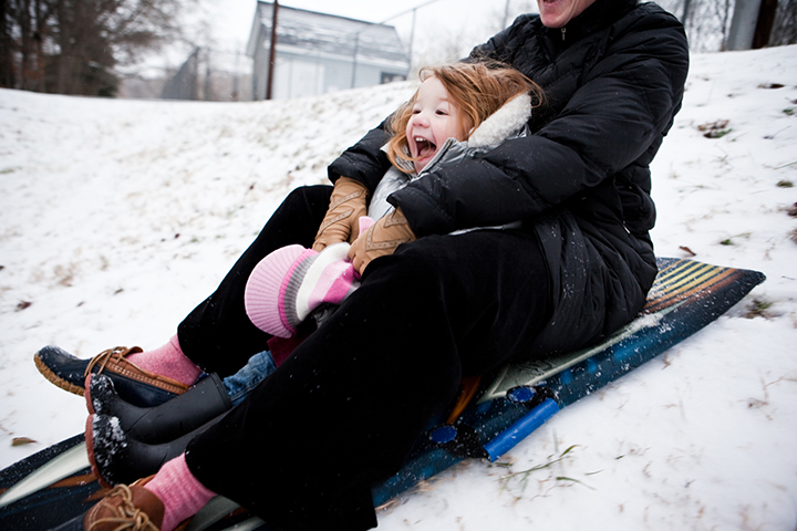 girl sledding with mother